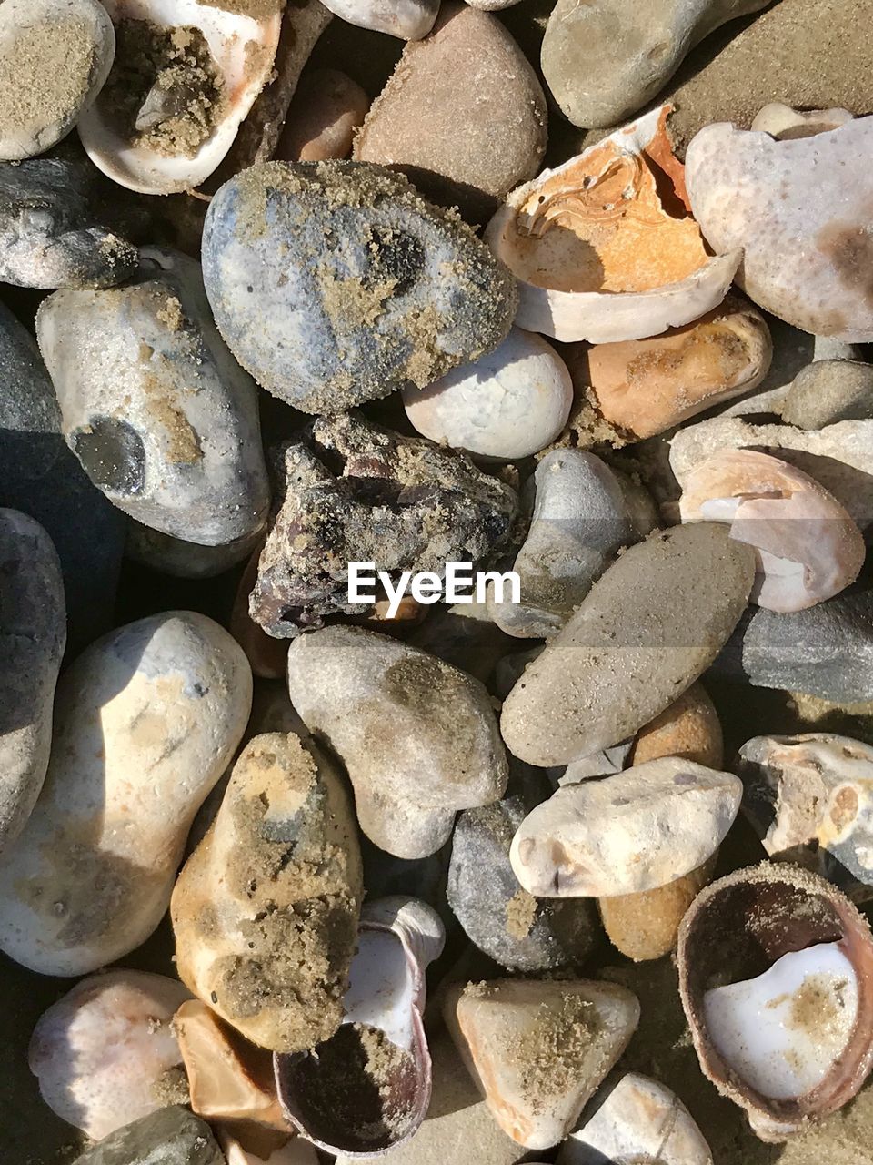 FULL FRAME SHOT OF PEBBLES ON ROCKS