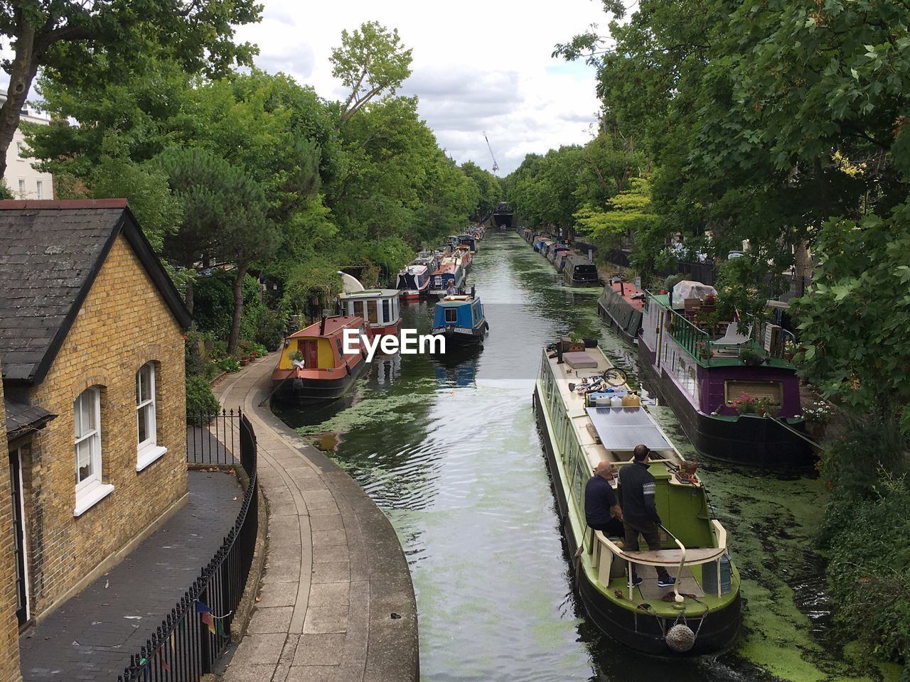 HIGH ANGLE VIEW OF RIVER AMIDST TREES AND BUILDINGS