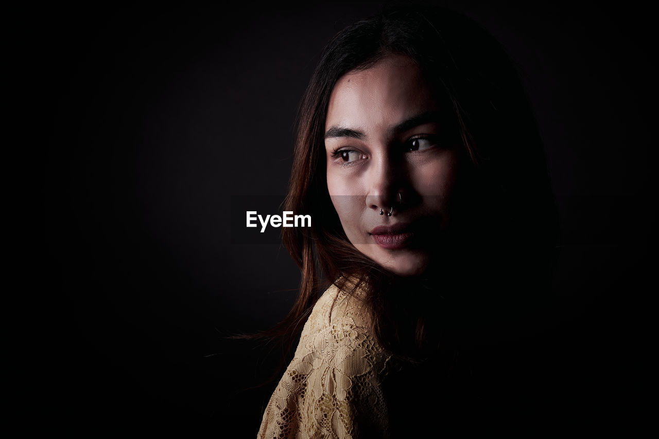 portrait, darkness, one person, looking at camera, black background, studio shot, adult, women, headshot, young adult, portrait photography, long hair, indoors, black, hairstyle, photo shoot, copy space, dark, emotion, female, brown hair, serious, human face, looking, person, fashion, front view