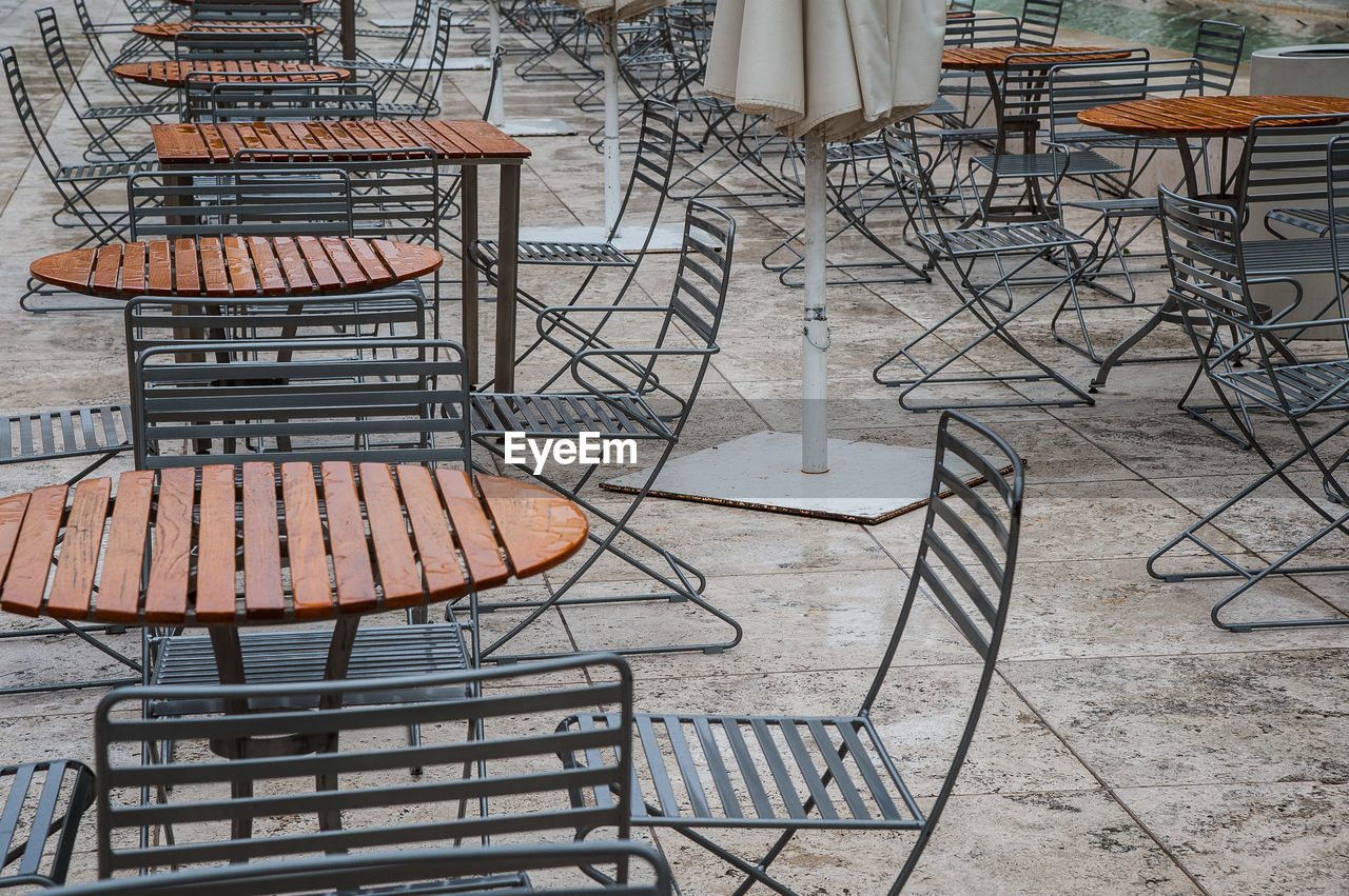 chair, seat, iron, table, furniture, no people, empty, sidewalk cafe, absence, cafe, day, arrangement, architecture, nature, restaurant, high angle view, outdoors, metal, in a row, sunlight, built structure