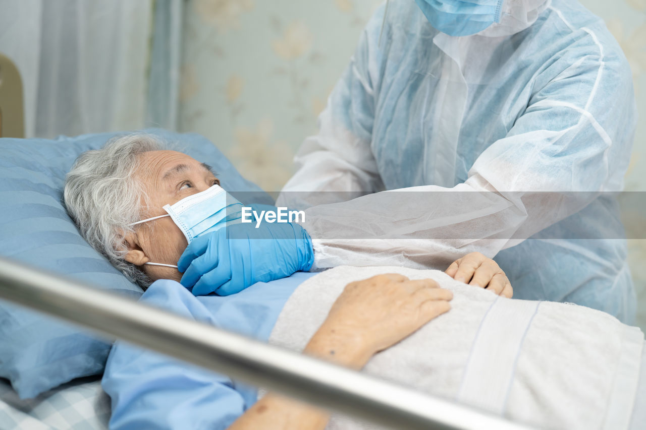 Midsection of doctor examining senior patient in hospital
