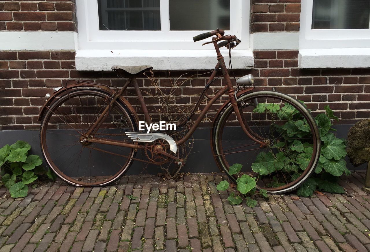 Abandoned bicycle on footpath by building