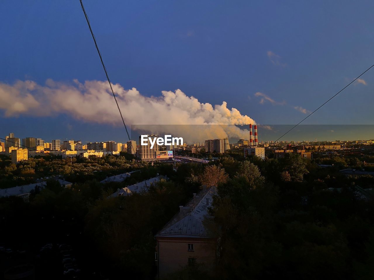 HIGH ANGLE VIEW OF BUILDINGS AND TREES AGAINST SKY