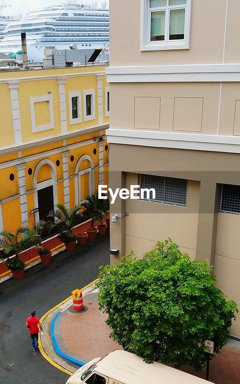 High angle view of man walking on road amidst buildings