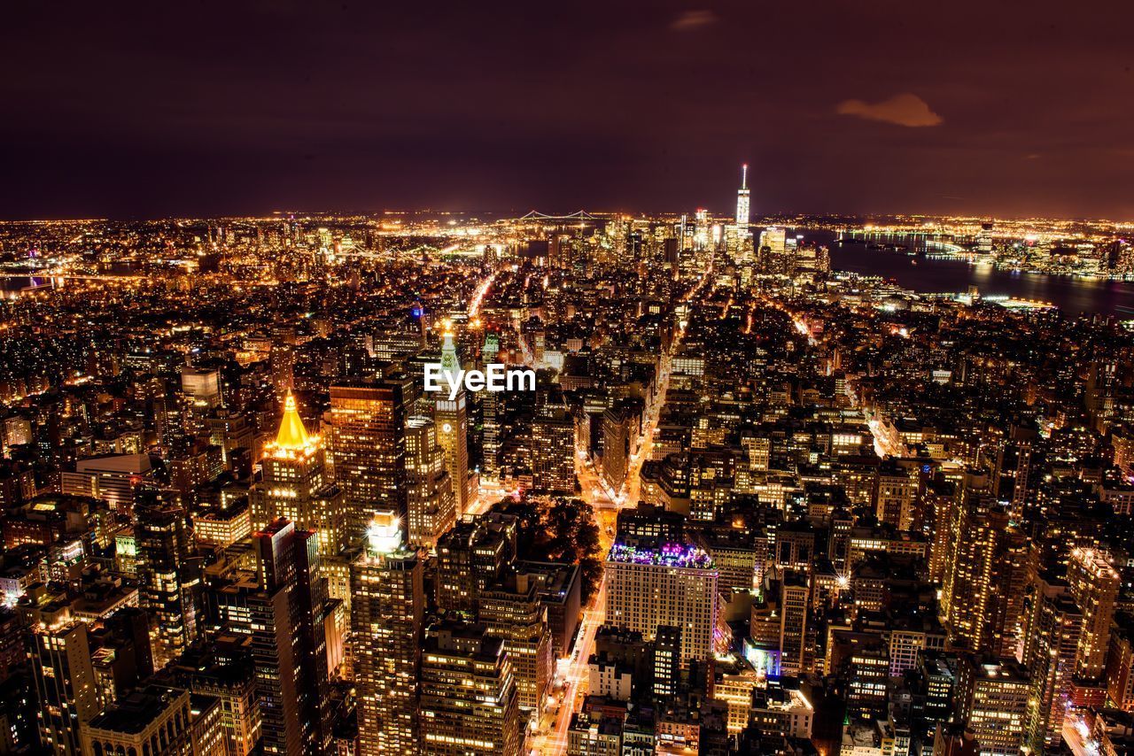 Illuminated cityscape against sky at night