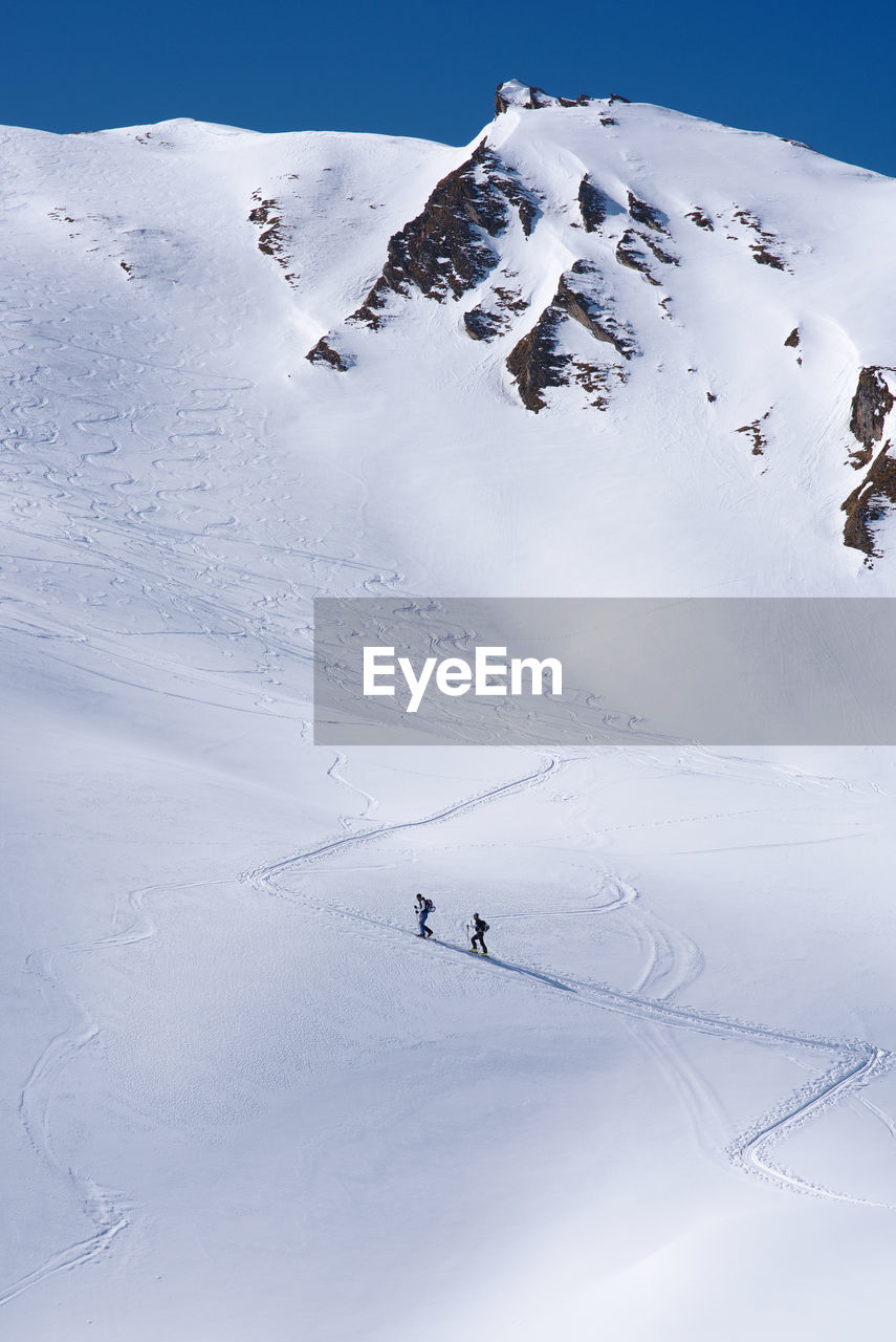 Hikers on snowcapped mountain