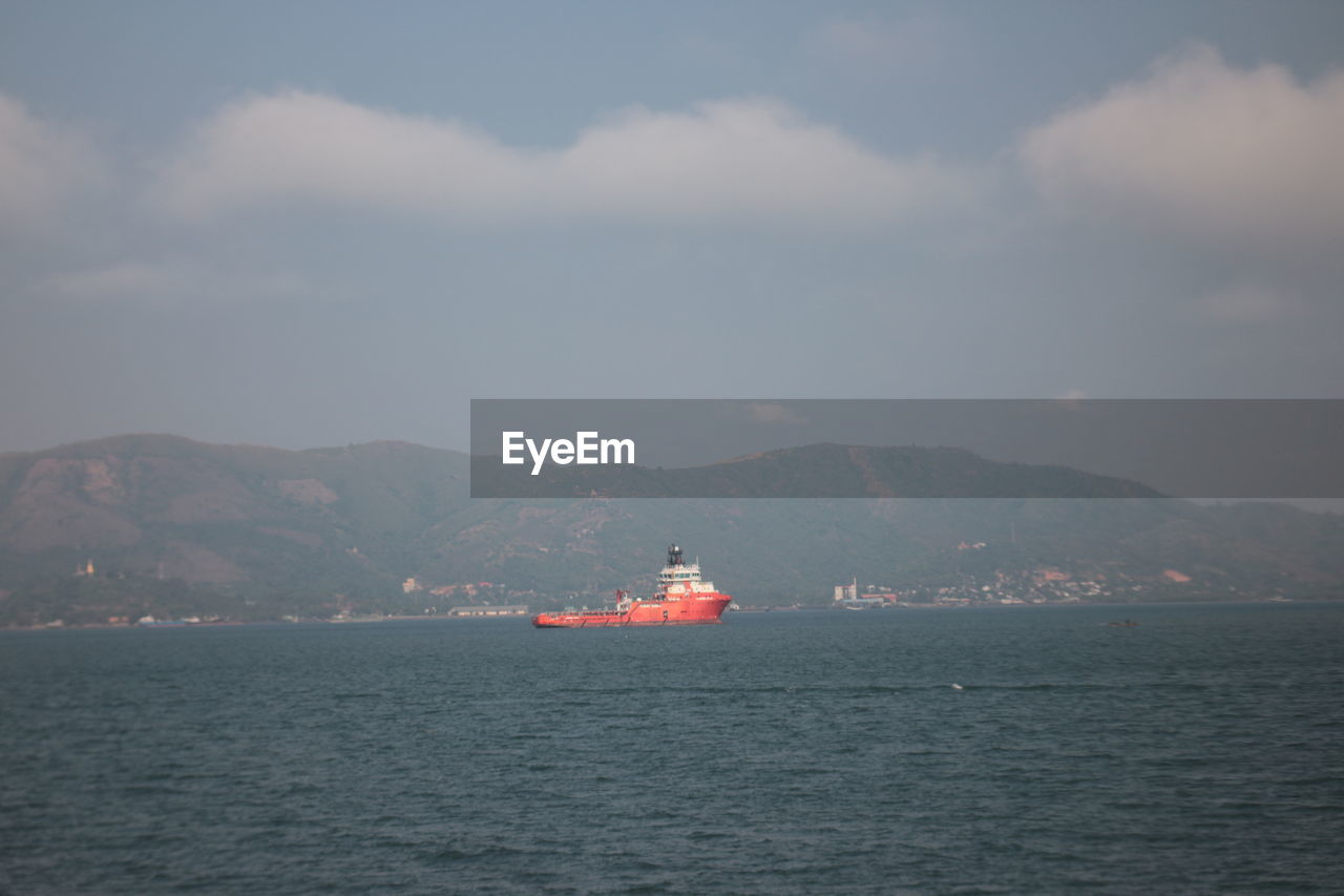 water, transportation, nautical vessel, sea, mountain, sky, cloud, ship, vehicle, mode of transportation, nature, horizon, ocean, no people, scenics - nature, watercraft, bay, coast, outdoors, ferry, passenger ship, day, travel, beauty in nature, boat, sailing, waterfront, architecture