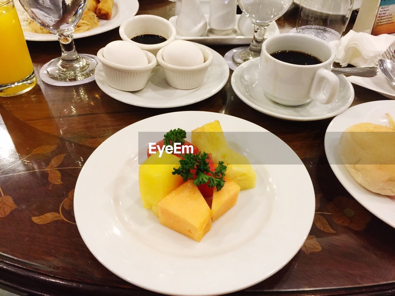 High angle view of breakfast served in plates by black coffee on table