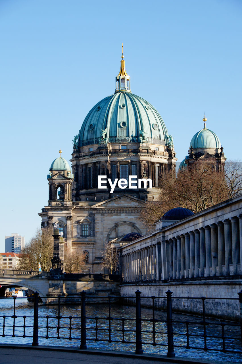 Berlin cathedral by spree river against blue sky