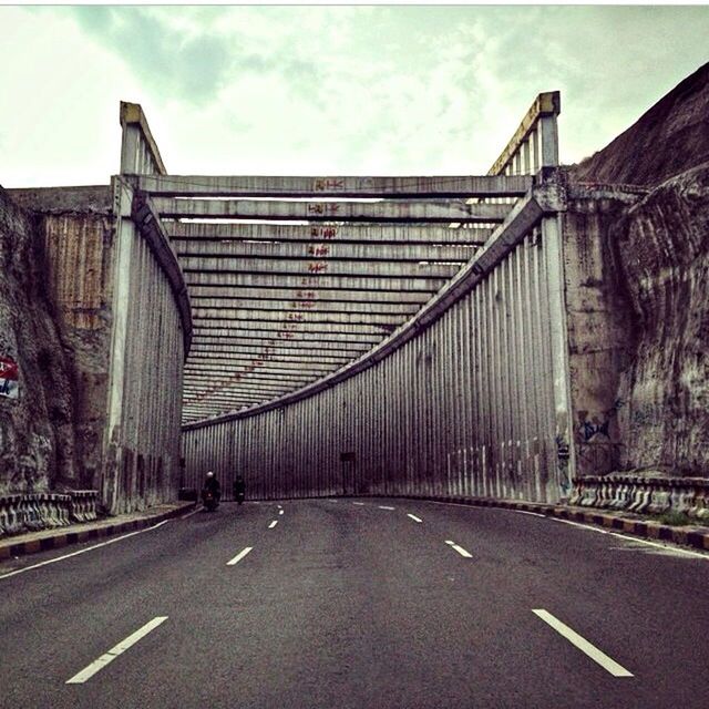 EMPTY ROAD WITH BRIDGE IN BACKGROUND