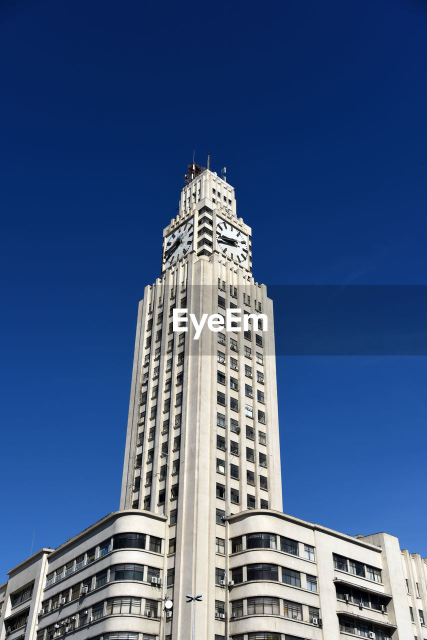 LOW ANGLE VIEW OF OFFICE BUILDING AGAINST BLUE SKY