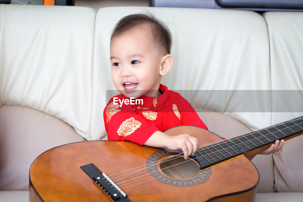 Portrait of cute boy playing guitar