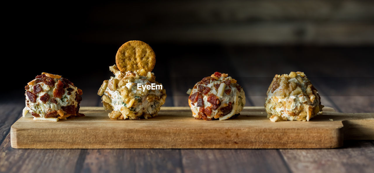 A row of dill pickle fat bombs for spreading on crackers, on a wooden board.