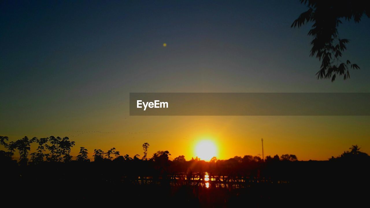 SCENIC VIEW OF SILHOUETTE LANDSCAPE AGAINST CLEAR SKY AT SUNSET