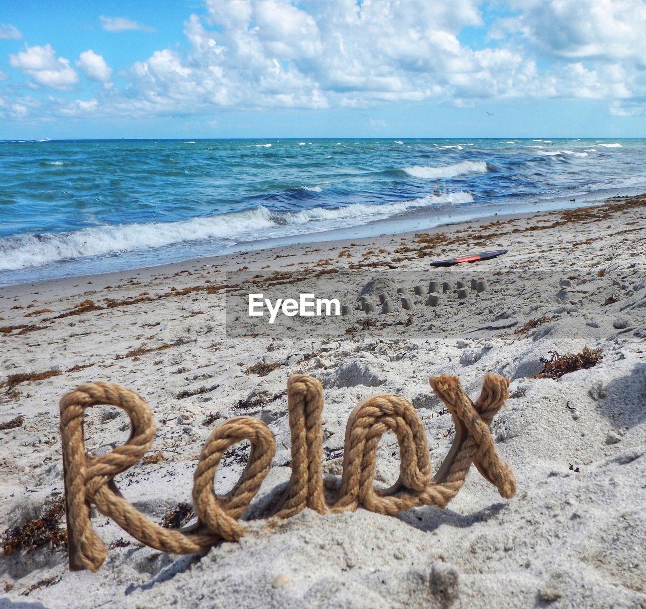 Text on sand at beach against sky