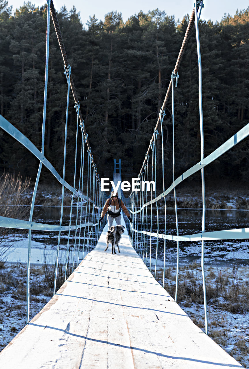 rear view of man walking on footbridge