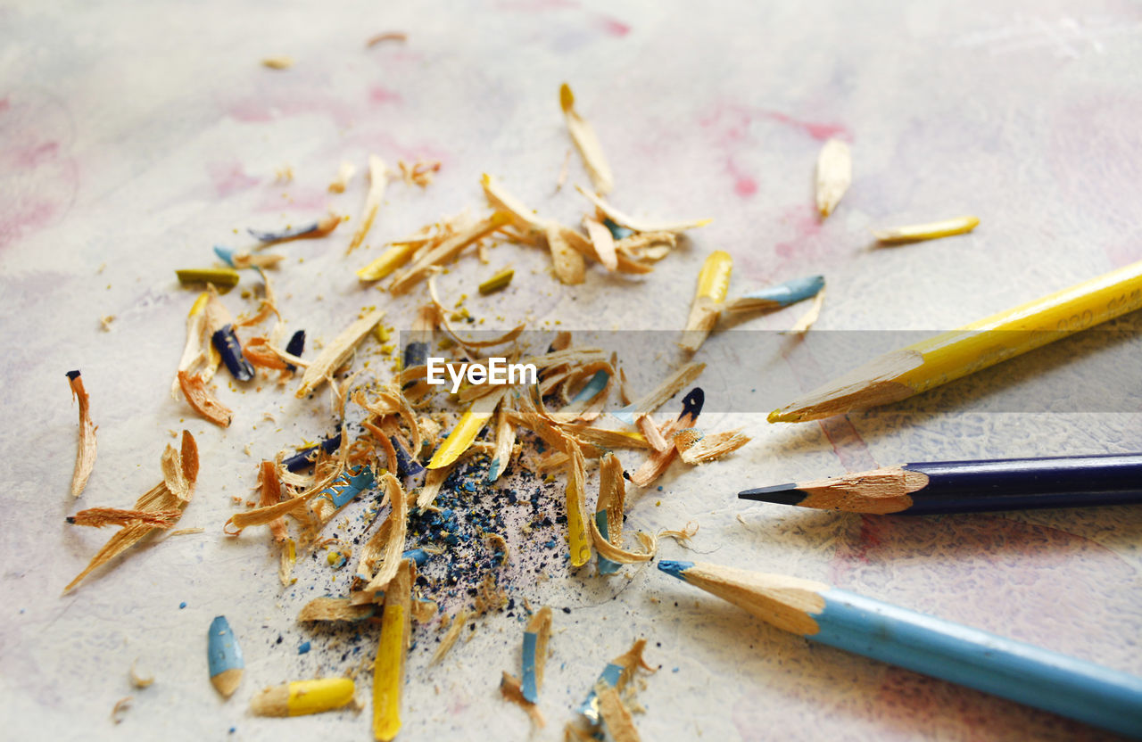 High angle view of colored pencils and shavings on table