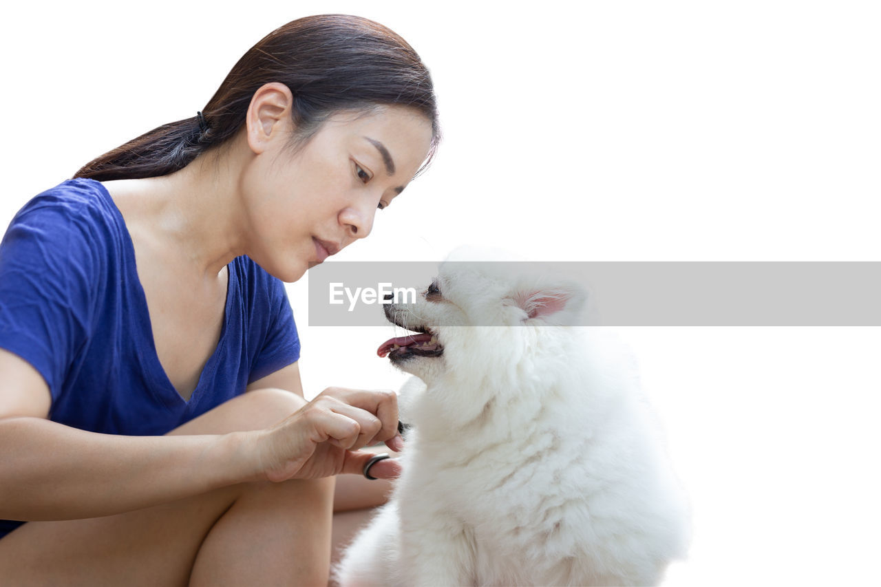 YOUNG WOMAN WITH CAT AGAINST WHITE