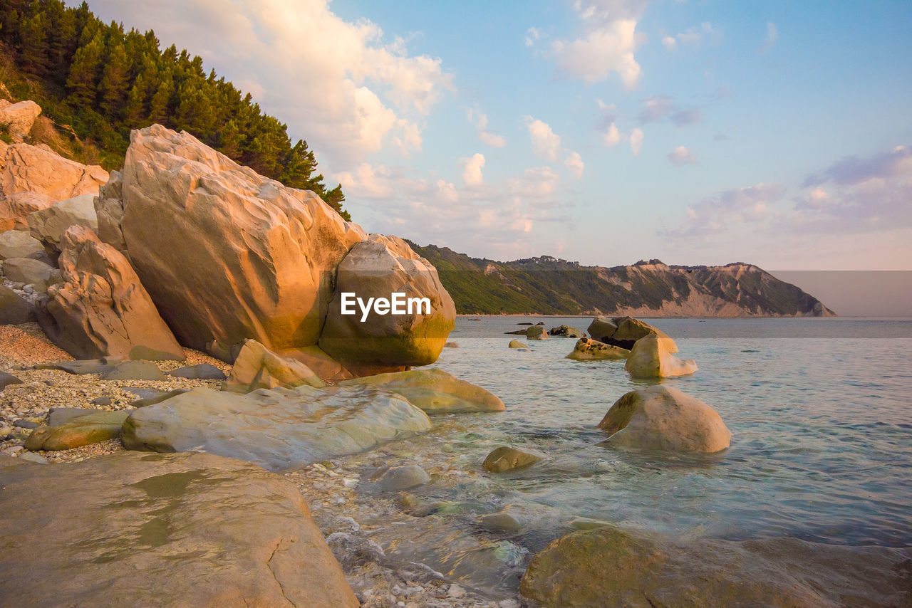 Rocks on sea shore against sky