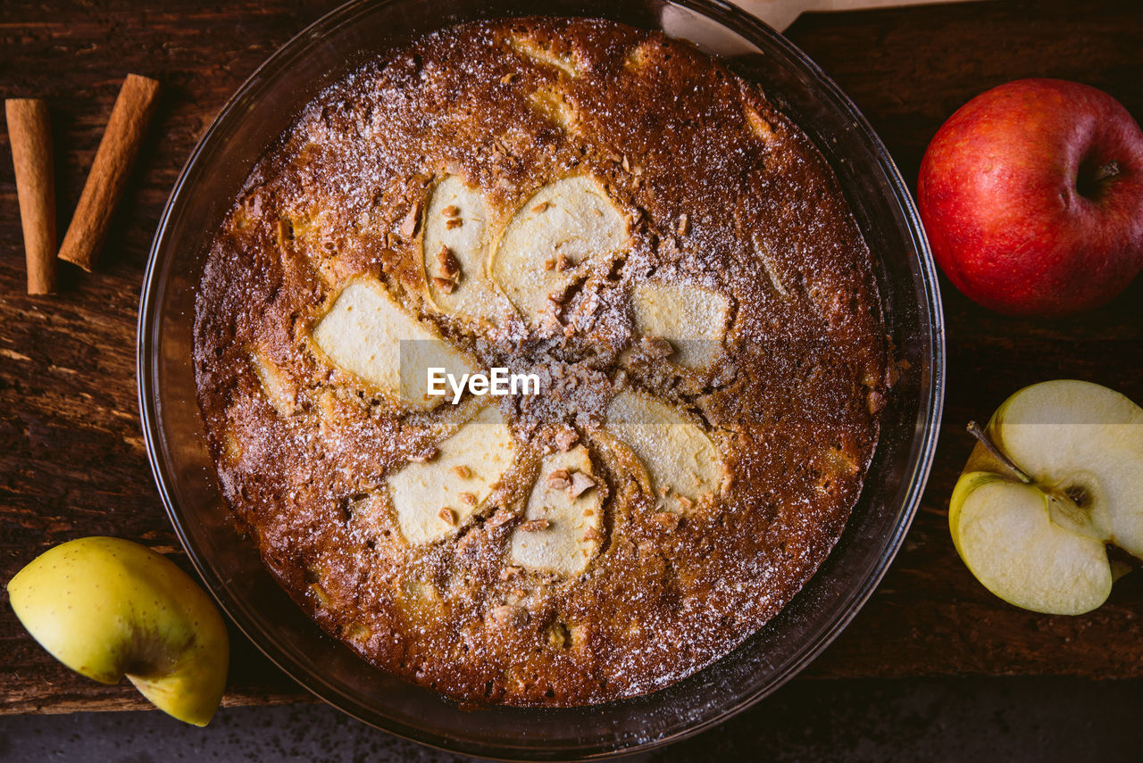 Top view of whole homemade apple pie on rustic brown burlap fabric with soft natural ì