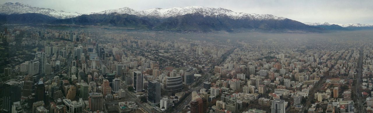 Panoramic view of cityscape by snowcapped mountains