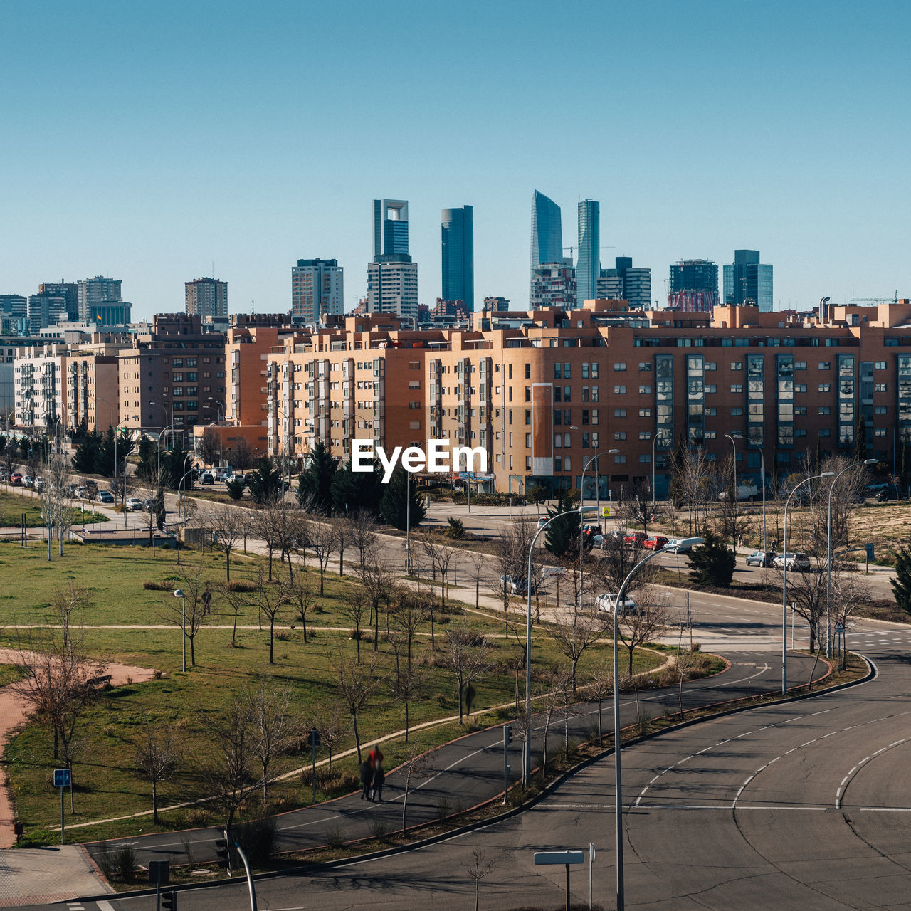 HIGH ANGLE VIEW OF STREET AMIDST BUILDINGS AGAINST CLEAR SKY