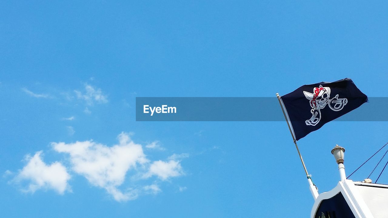 Low angle view of pirate flag against sky