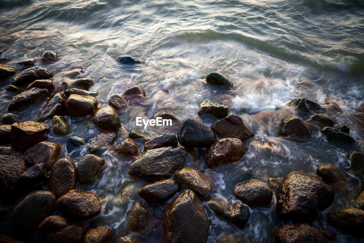 Close-up of pebbles in sea