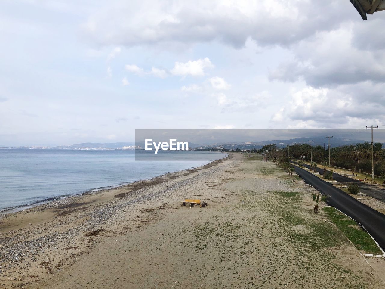 VIEW OF ROAD BY SEA AGAINST SKY