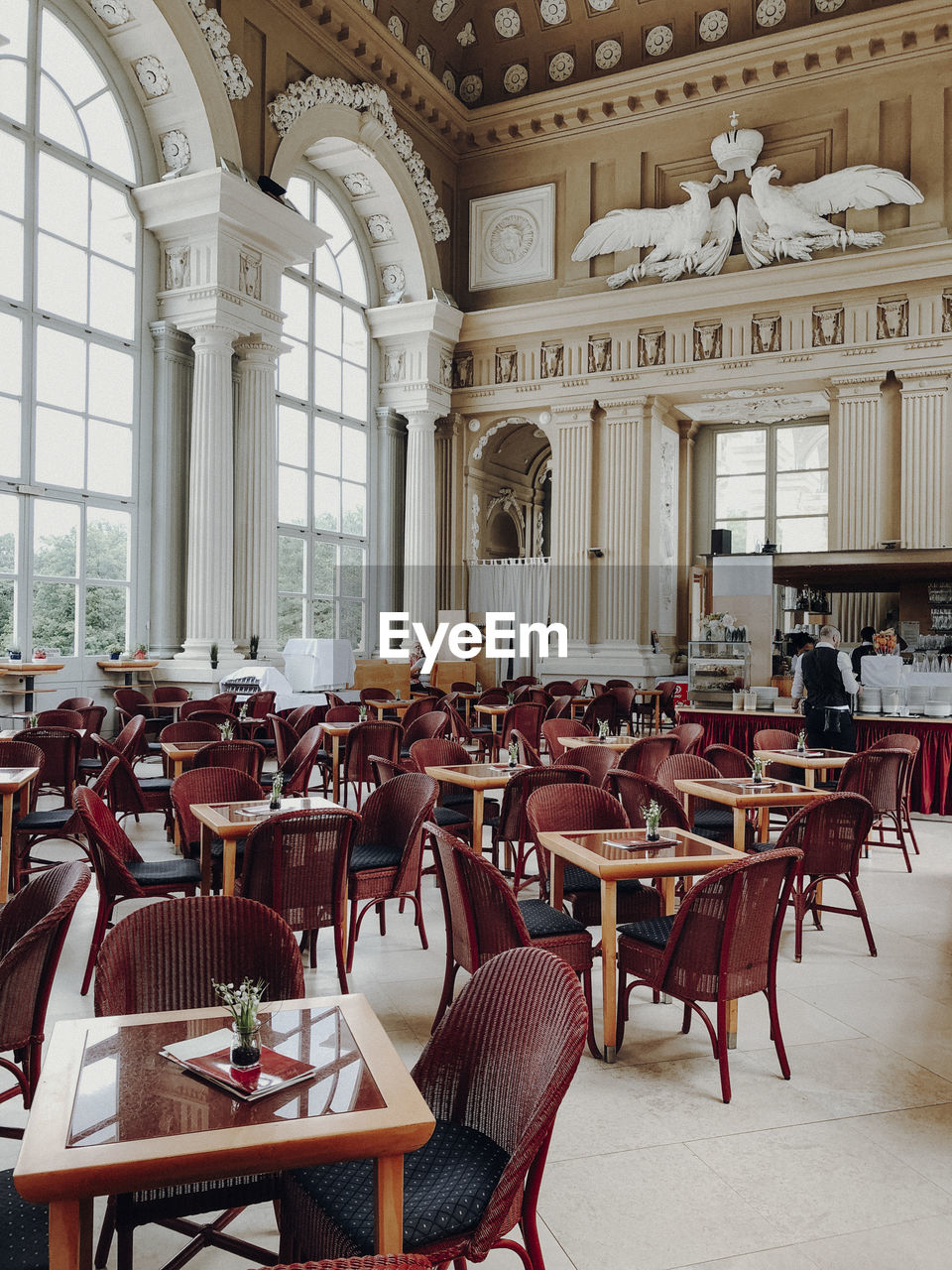 EMPTY CHAIRS AND TABLES IN CAFE AGAINST BUILDINGS