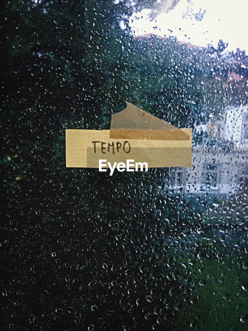 Text stuck on glass window of home during rainy season