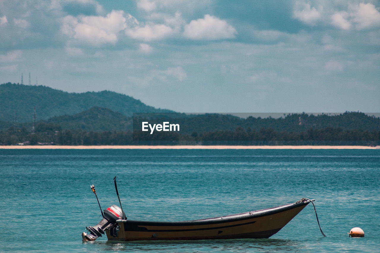 BOATS IN LAKE AGAINST SKY