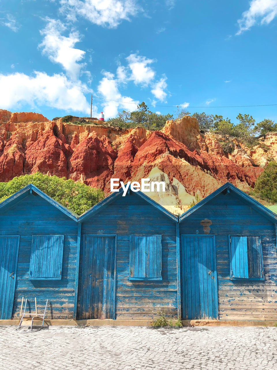 BUILT STRUCTURE ON LAND AGAINST BLUE SKY AND MOUNTAINS