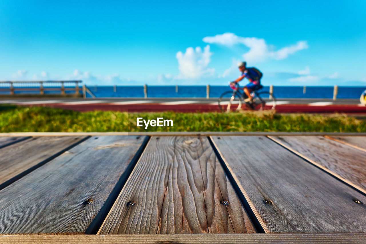 MAN ON PIER OVER SEA AGAINST BLUE SKY