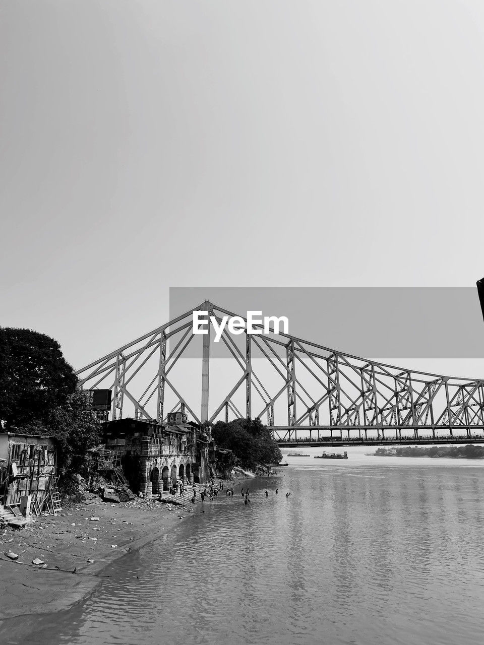 architecture, built structure, black and white, water, bridge, sky, monochrome, monochrome photography, transportation, nature, travel destinations, copy space, cantilever bridge, no people, travel, outdoors, day, clear sky, sea, city, tourism, building exterior, tree, environment, waterfront, metal