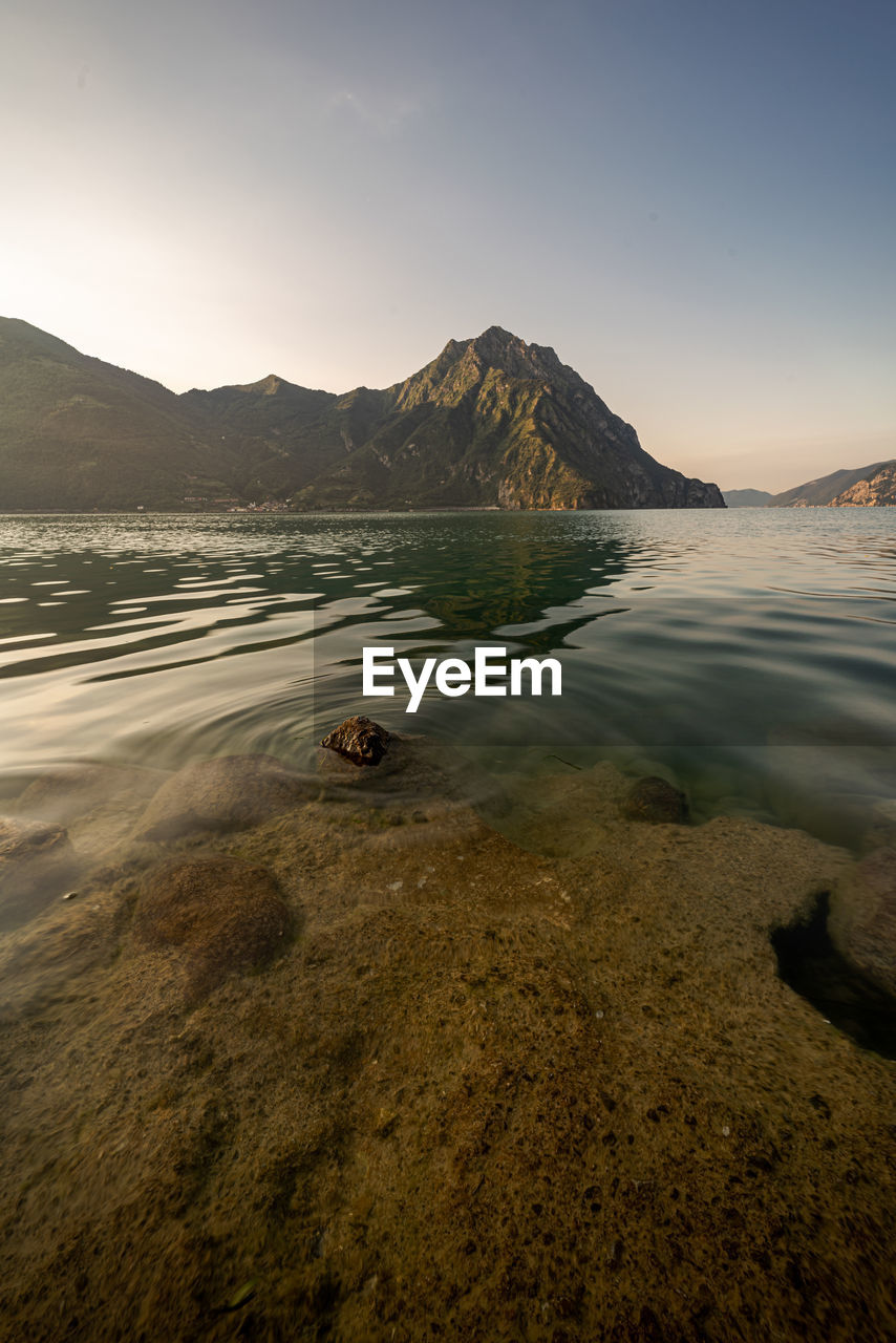 Scenic view of sea and mountains against sky