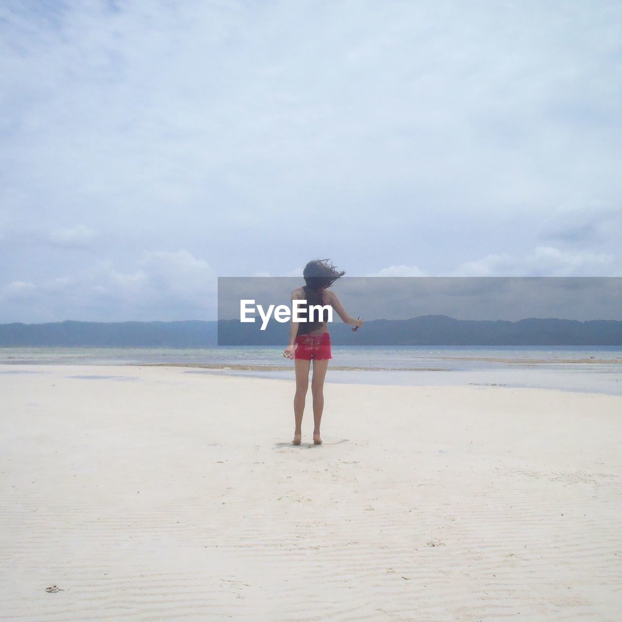 WOMAN STANDING ON BEACH