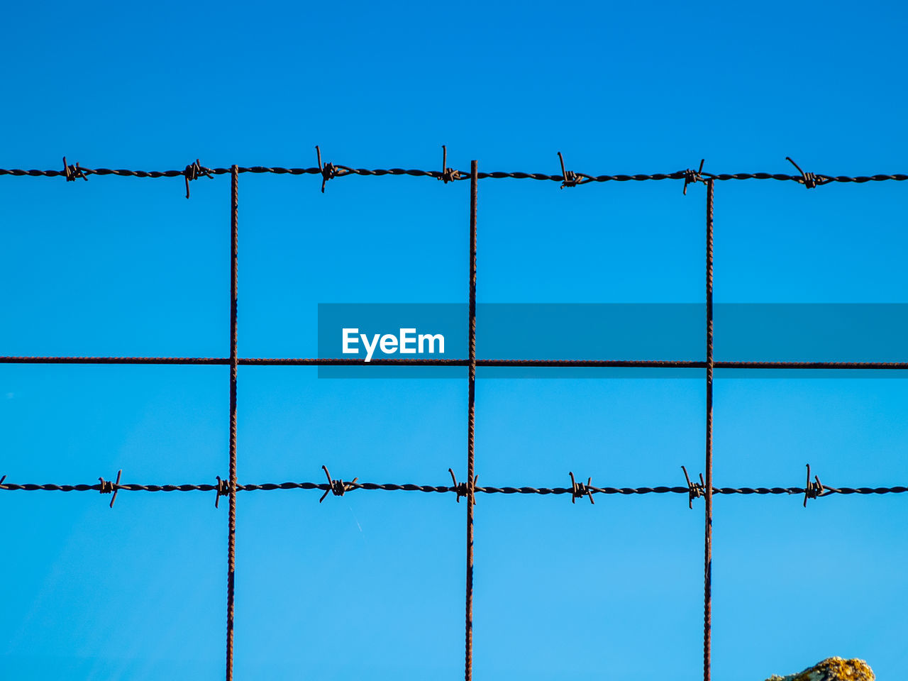 LOW ANGLE VIEW OF BARBED WIRE AGAINST SKY