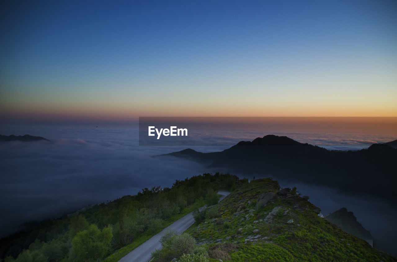 Scenic view of mountain amidst cloudscape against sky