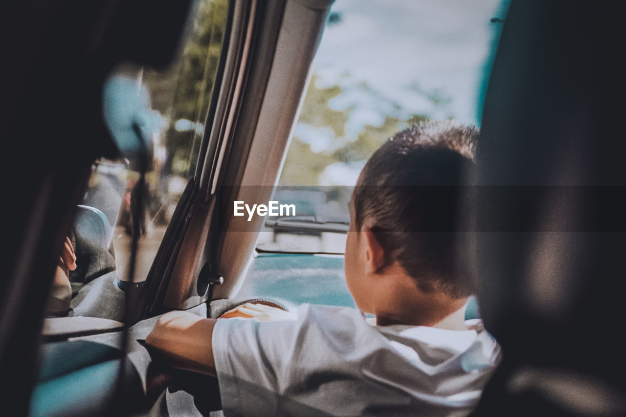 REAR VIEW PORTRAIT OF BOY IN CAR