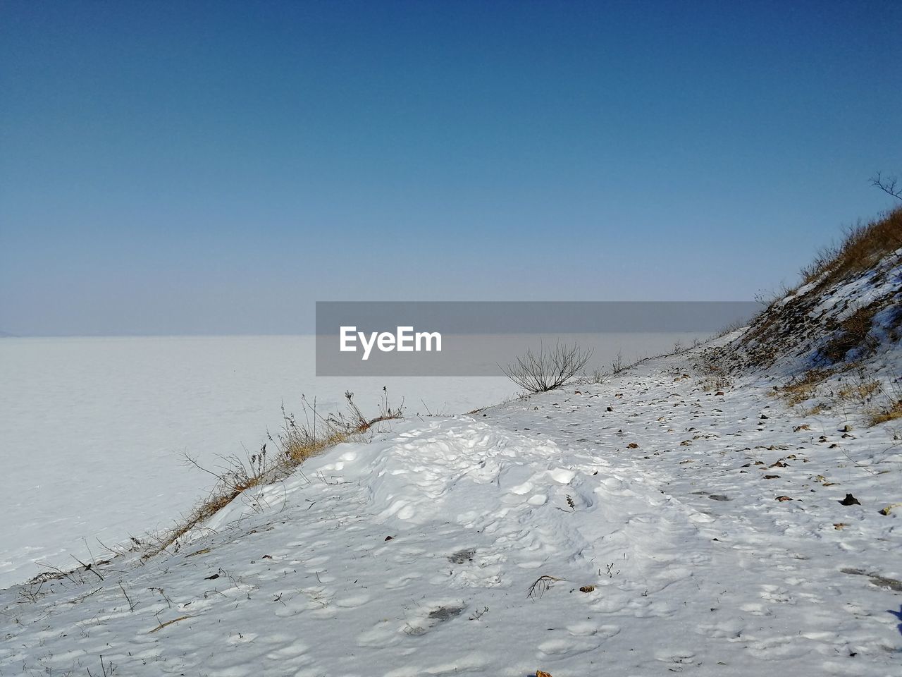 SCENIC VIEW OF SNOW COVERED LAND AGAINST CLEAR SKY DURING WINTER