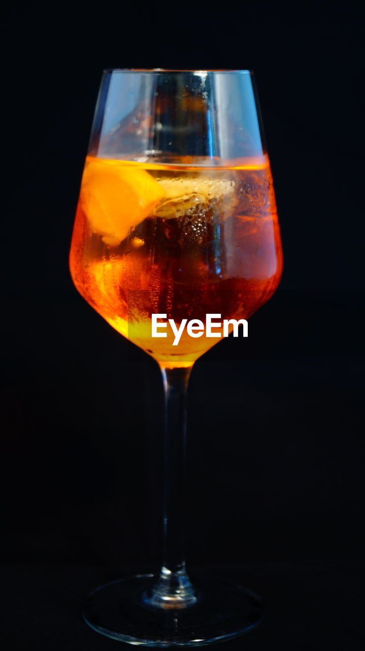 Alcohol in wineglass against black background