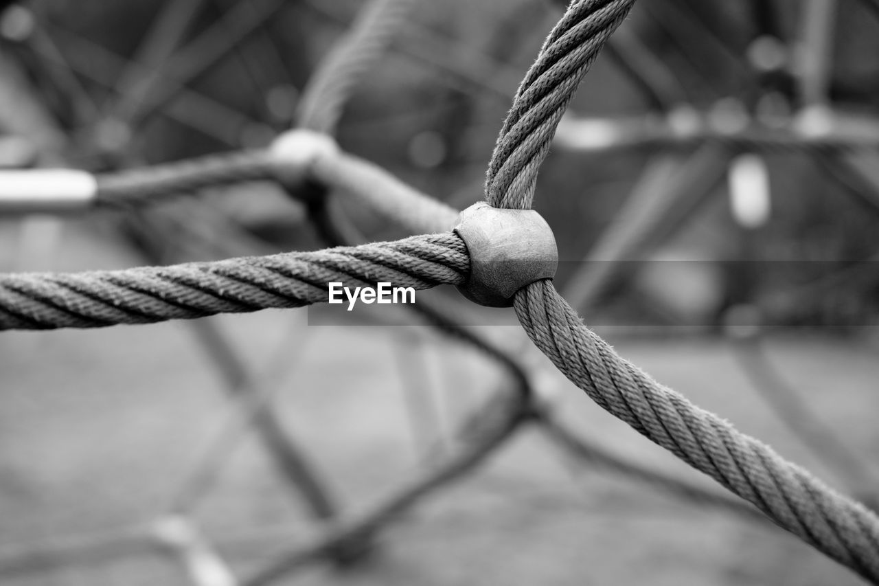 CLOSE-UP OF ROPE TIED UP ON METAL FENCE