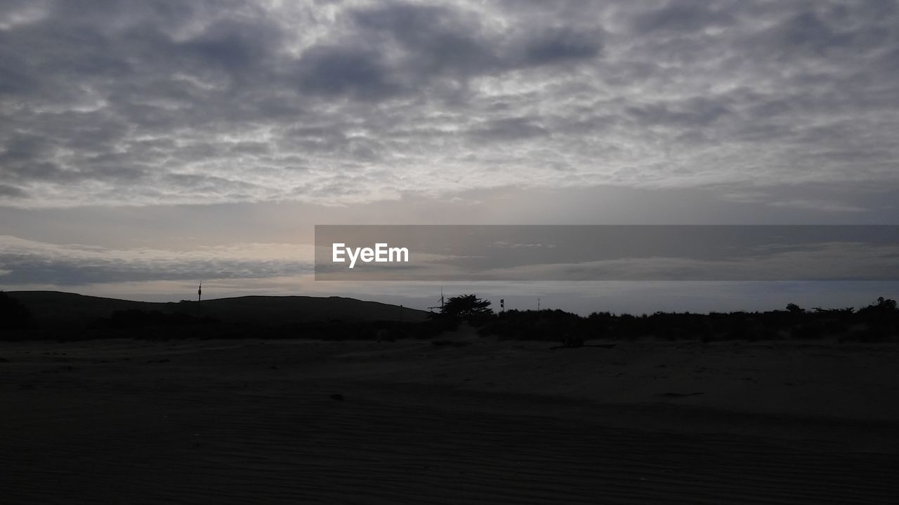 SCENIC VIEW OF LANDSCAPE AGAINST CLOUDY SKY AT SUNSET