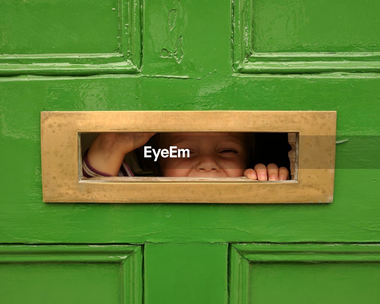Close-up of boy looking through hole 