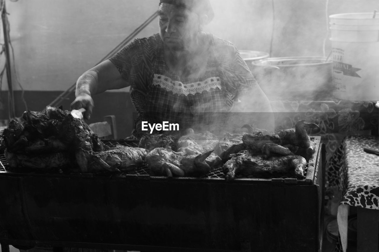 MAN PREPARING FOOD FOR SALE AT MARKET