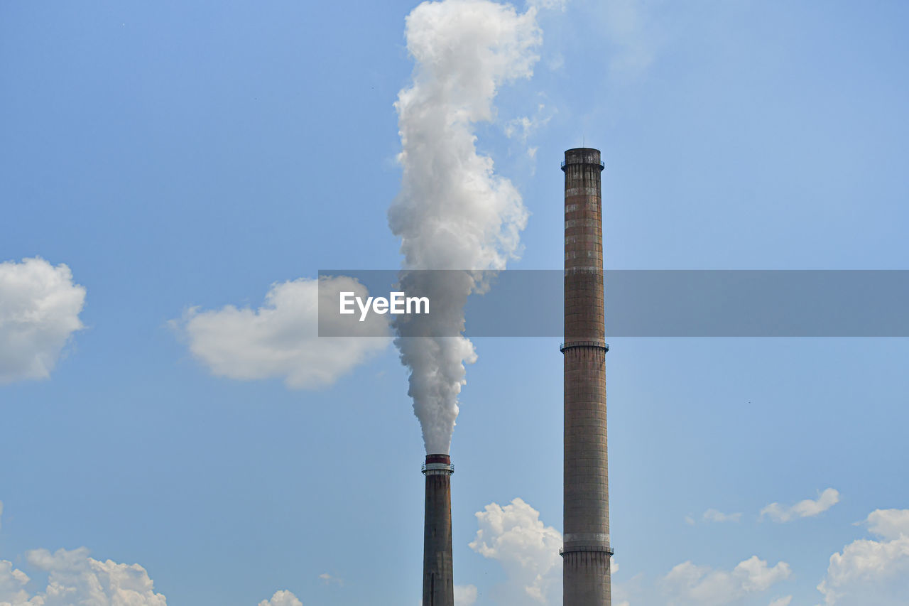 Low angle view of smoke stack against sky