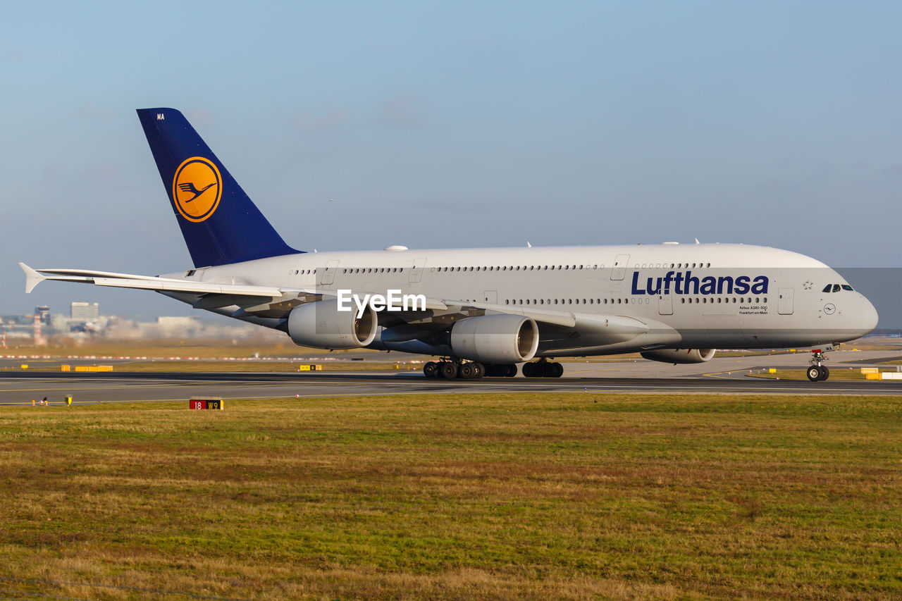 SIDE VIEW OF AIRPLANE ON RUNWAY AGAINST SKY