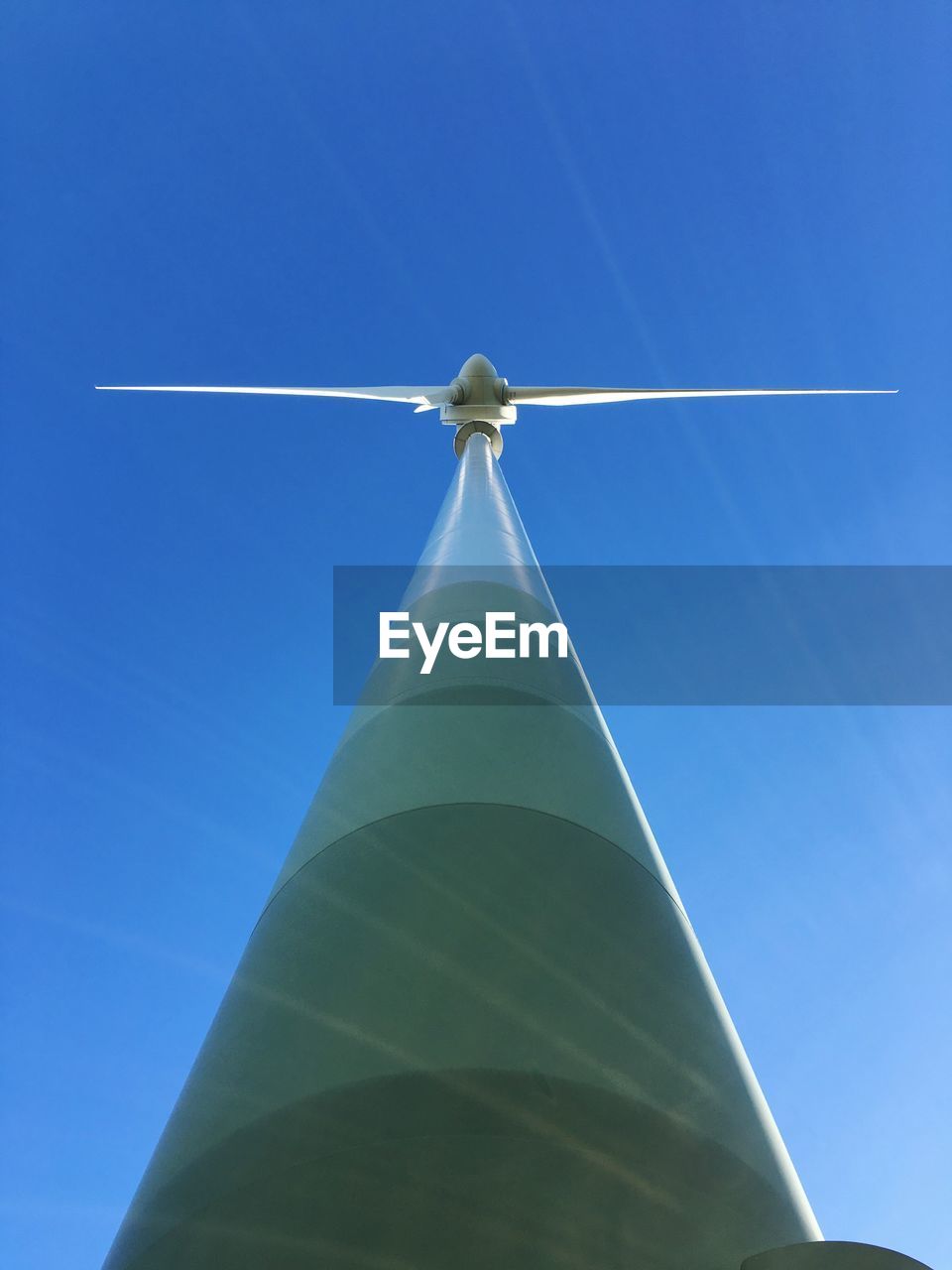 Low angle view of windmill against clear blue sky