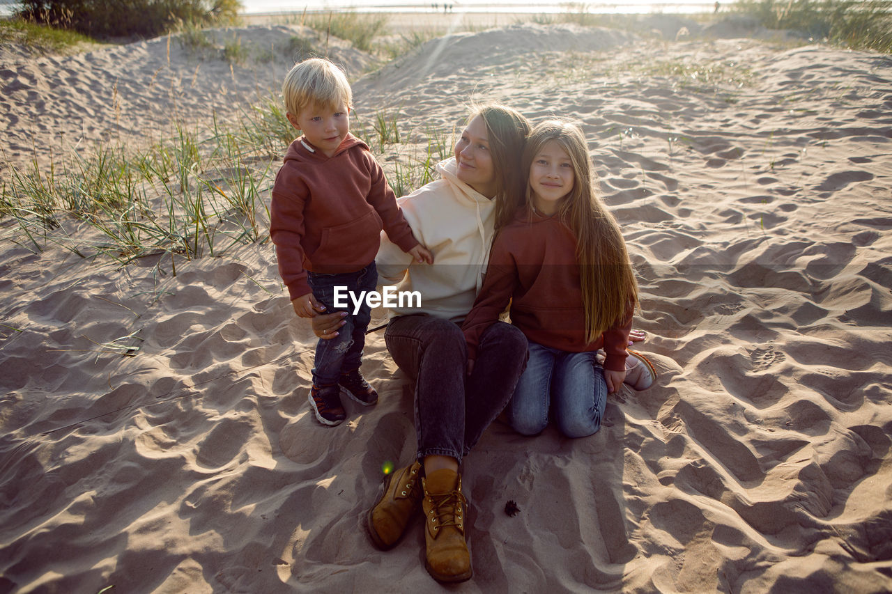 Photographer shoots family in autumn on the sand by the sea